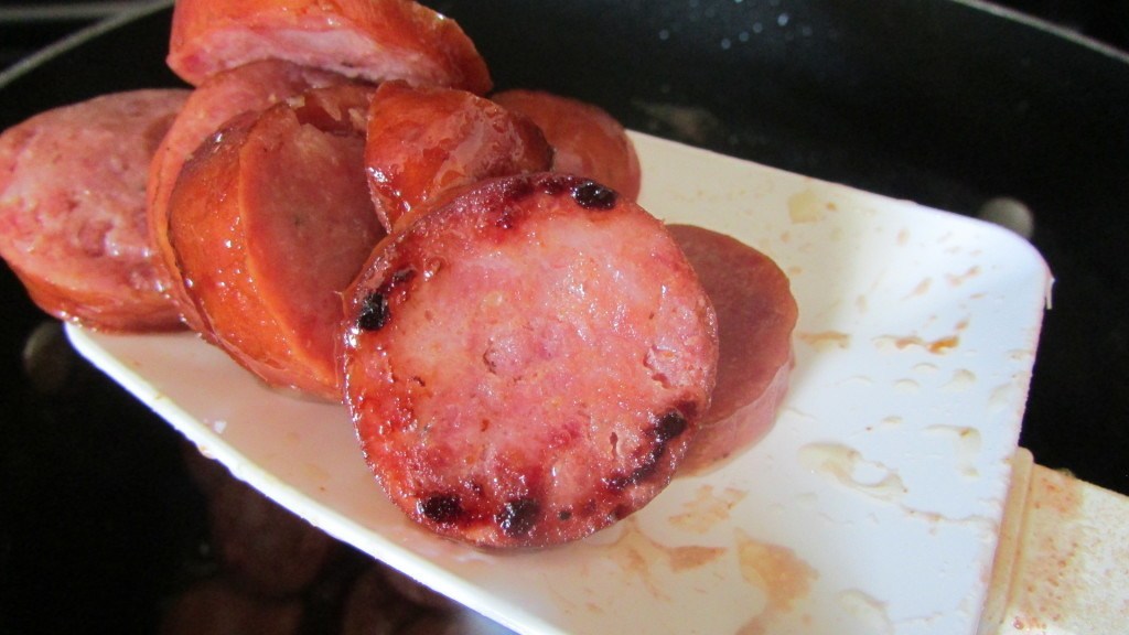 Cooked sliced sausage on silicone spatula
