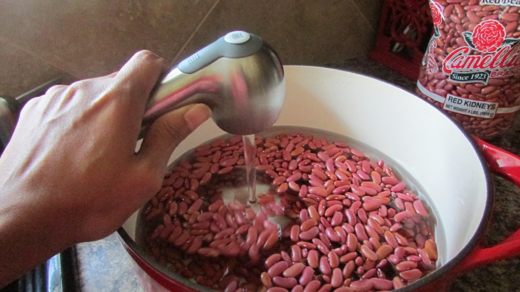 Red beans in a pot with water being poured in to soak red beans