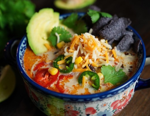 bowl of creamy chicken tortilla soup with cilantro, jalapeño, and lime